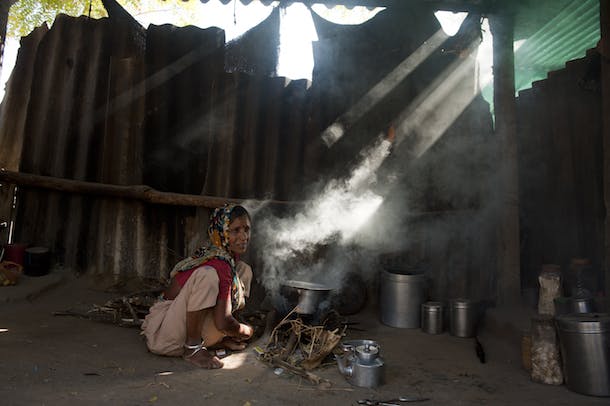 Dadam Ben tries to light the fire in the conventional cookstove in Ganeshpura village in District Mehsana in Indian State of Gujarat.