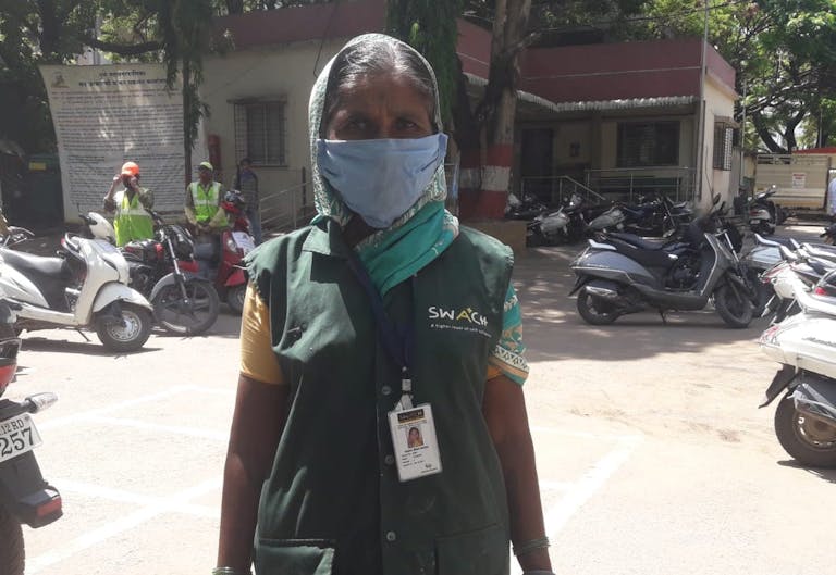 woman in a surgical mask prepares for work
