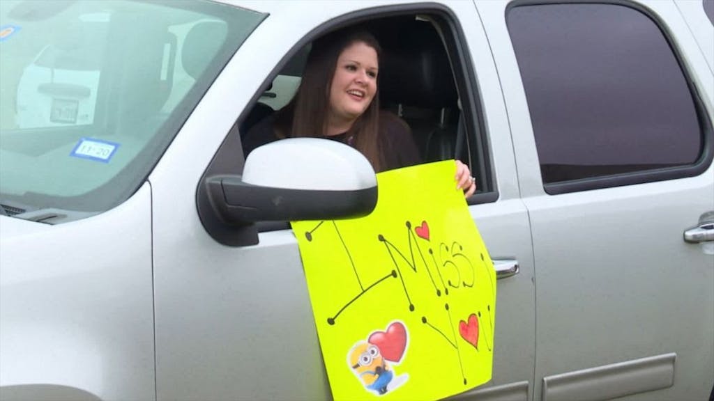 Woman in car with I miss you sign