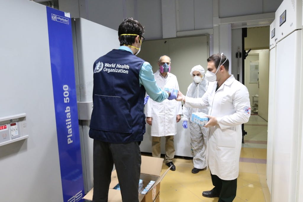 WHO staffer gives iranian medical personell covid-19 equipment