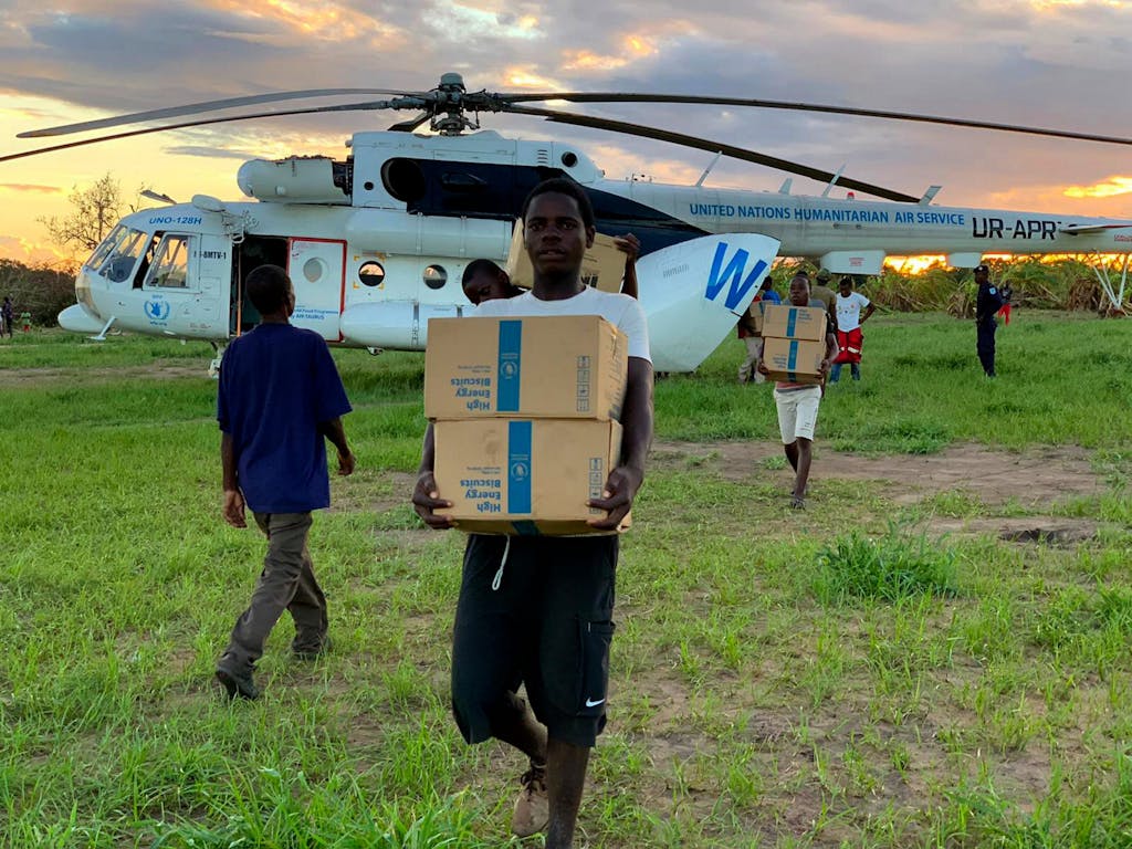 A young man carries supplies from a UN helicopter.
