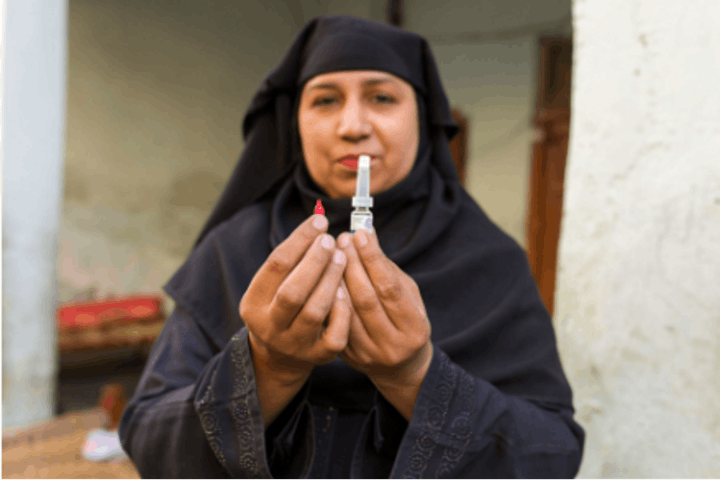 Naureen, a community-based vaccinator in Pakistan, prepares to administer the oral polio vaccine..